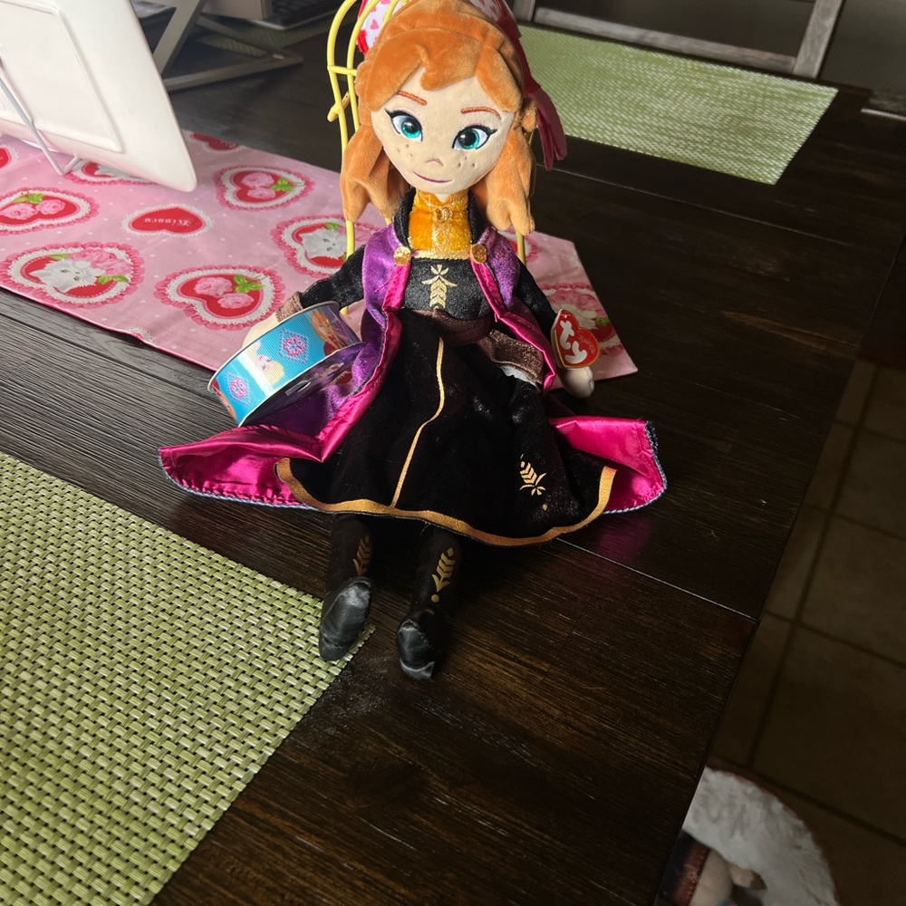 NWT Ty Anna doll from frozen. She comes with a new roll of Elsa and Anna ribbon.